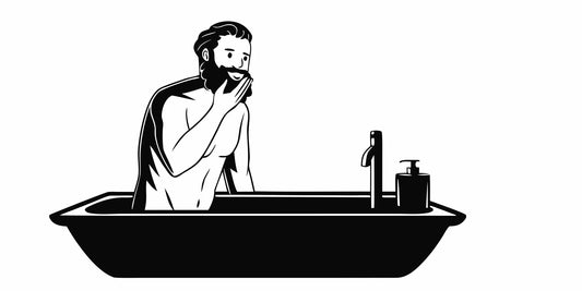 Bearded man washing his face with a gentle cleanser in a modern bathroom
